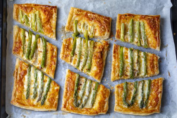 Baked green asparagus with ham and cheese in puff pastry